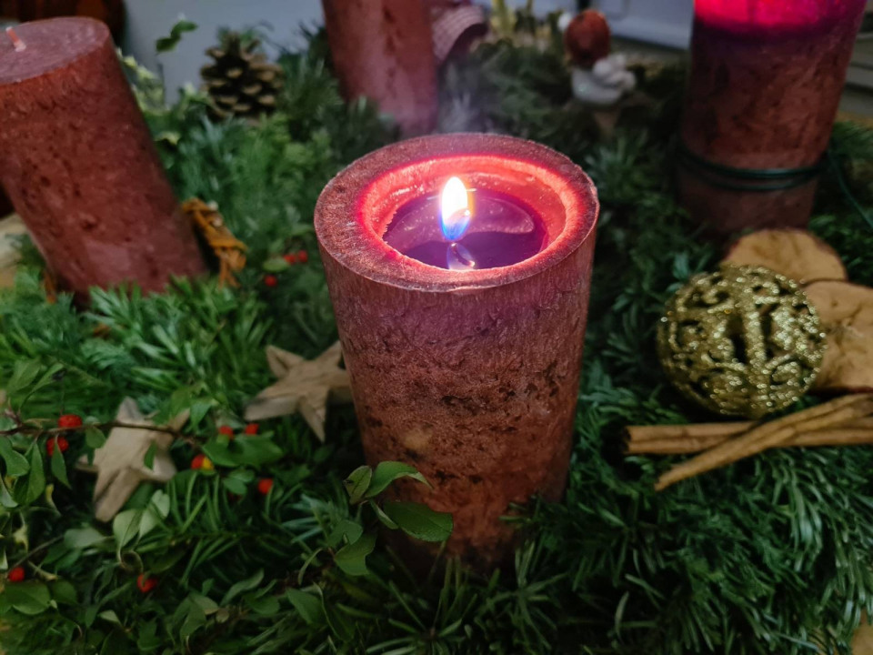 Brennende rote Kerze auf Adventkranz